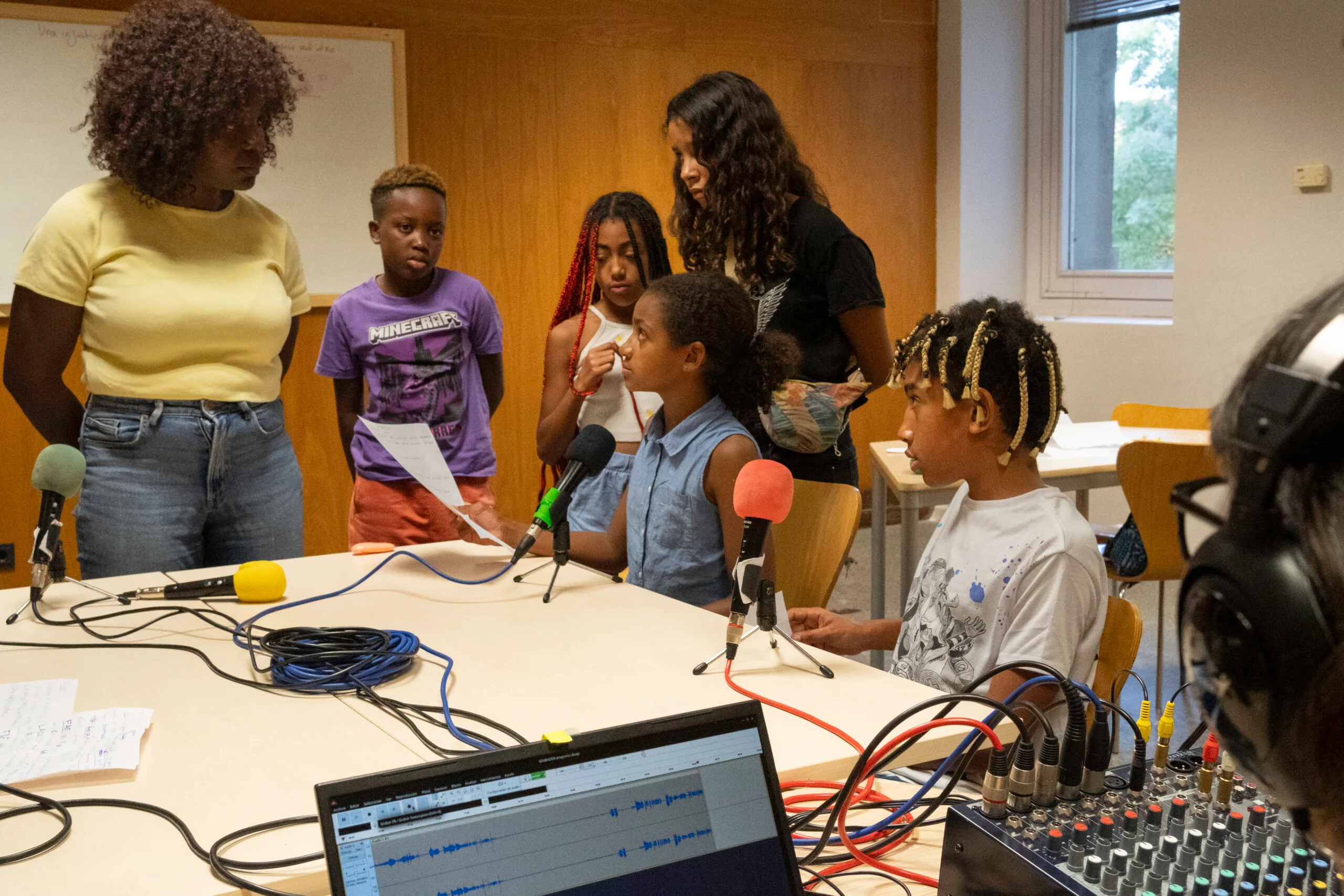 Micrófono y manos sobre la mesa, representando el tráiler sonoro del proyecto